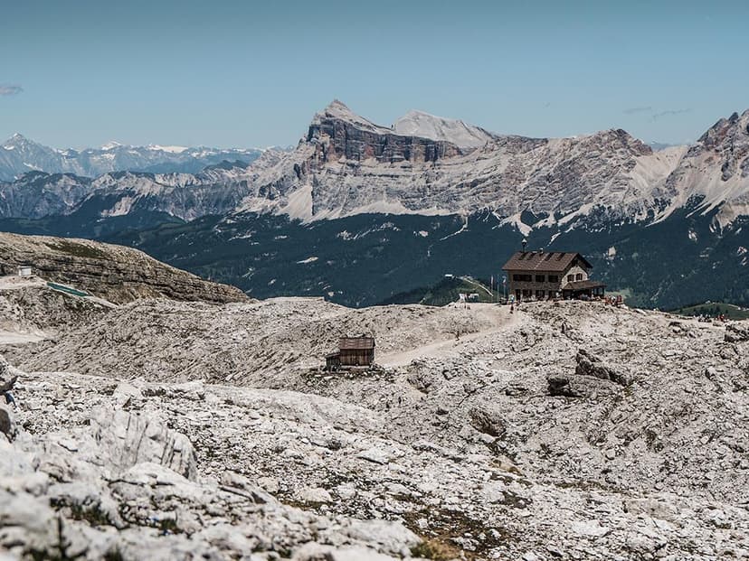 Franz Kostner Hut on rocky terrain with massive Dolomite mountains in the background
