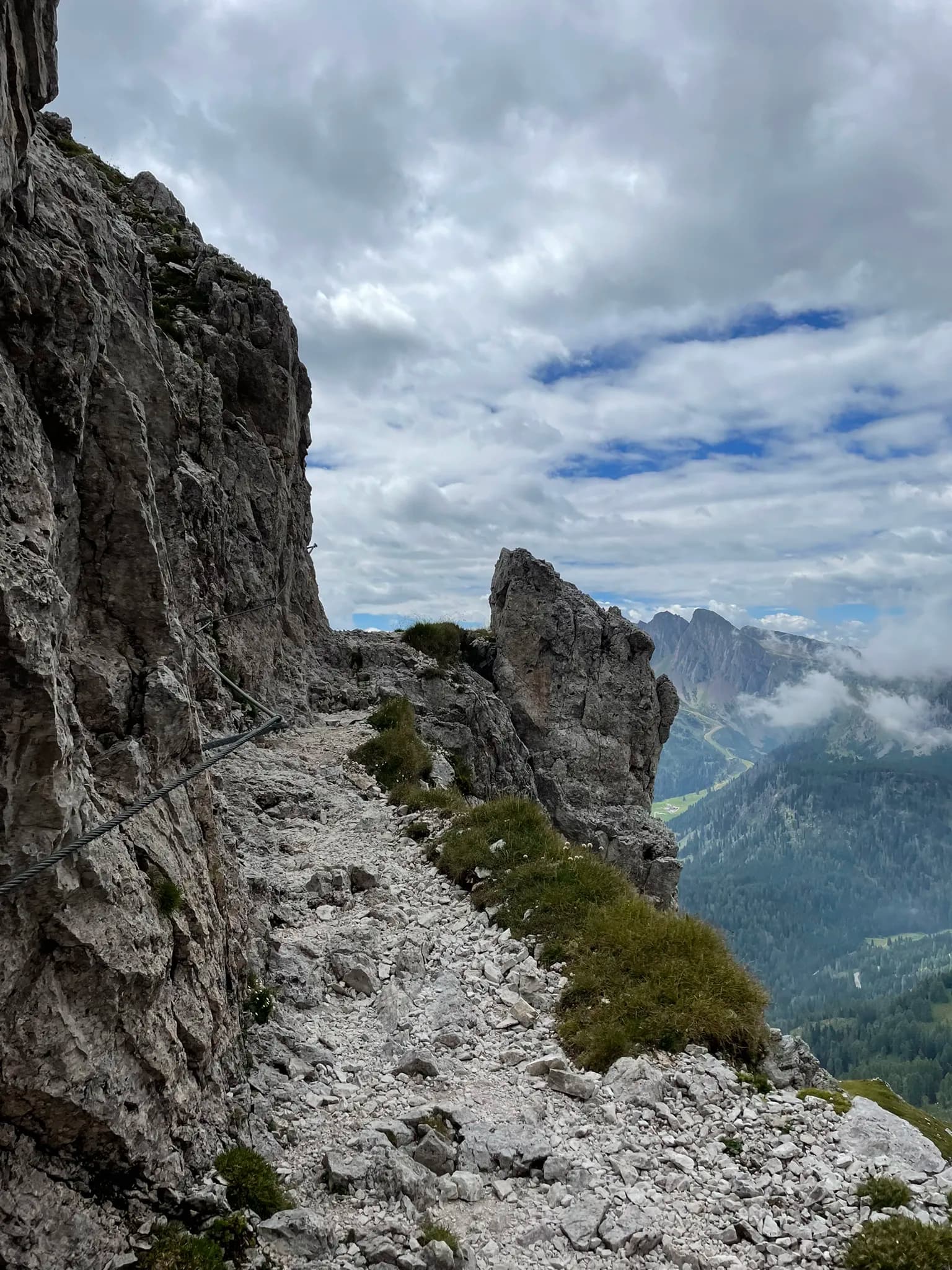 Rocky hiking trail with safety cable on the Pale di San Martino mountain range.