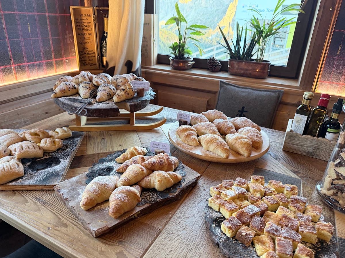 Assortment of croissants and pastries displayed on wooden boards in mountain cafe