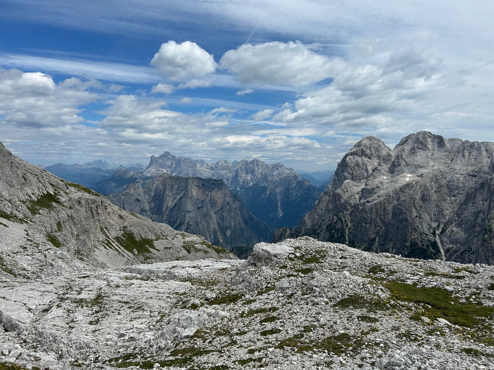 Rugged limestone mountain slopes and distant peaks under a partly cloudy sky