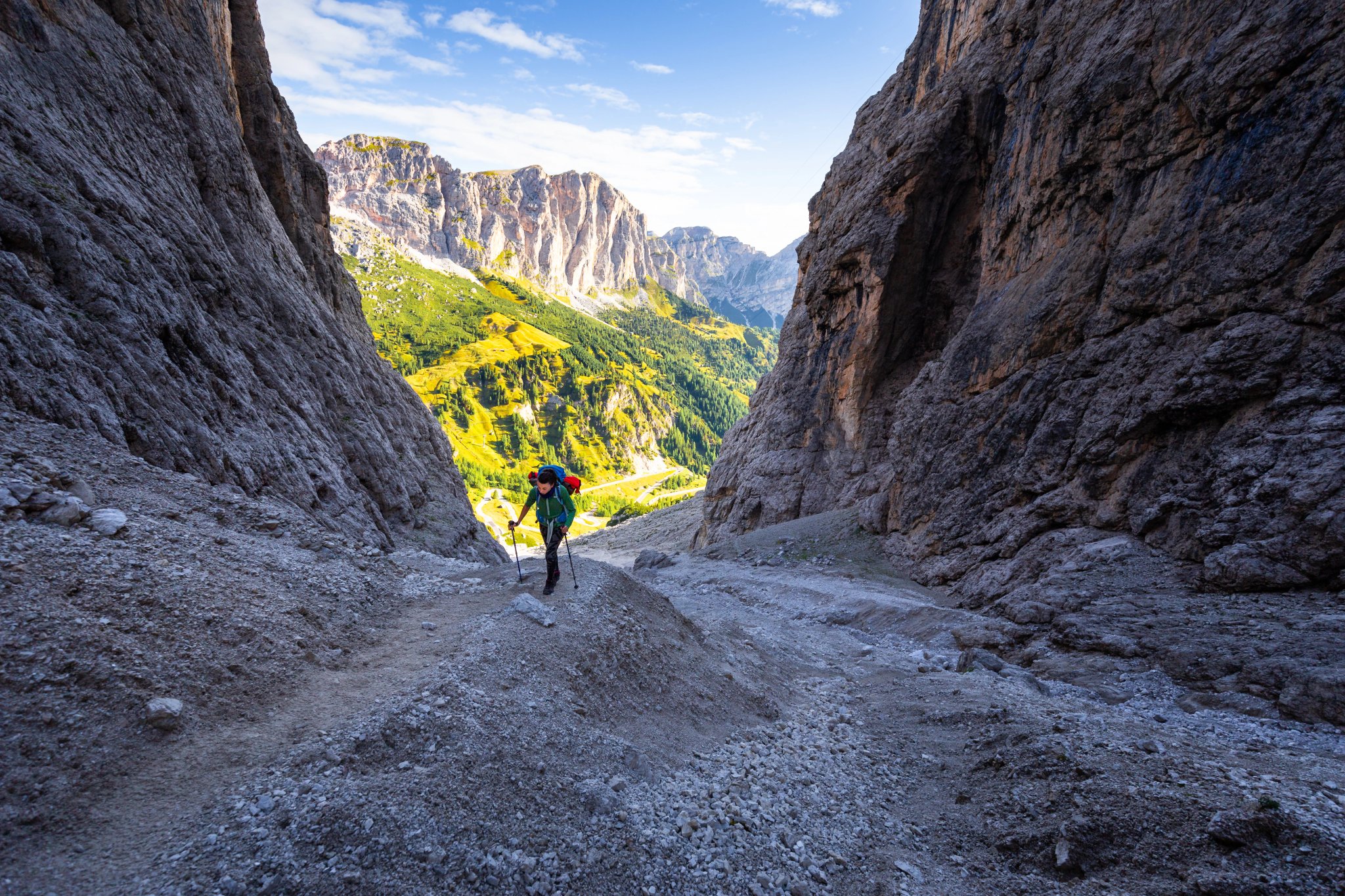 Woman hiking steep rocky mountain trail under cliffs of Alta Via 2 path