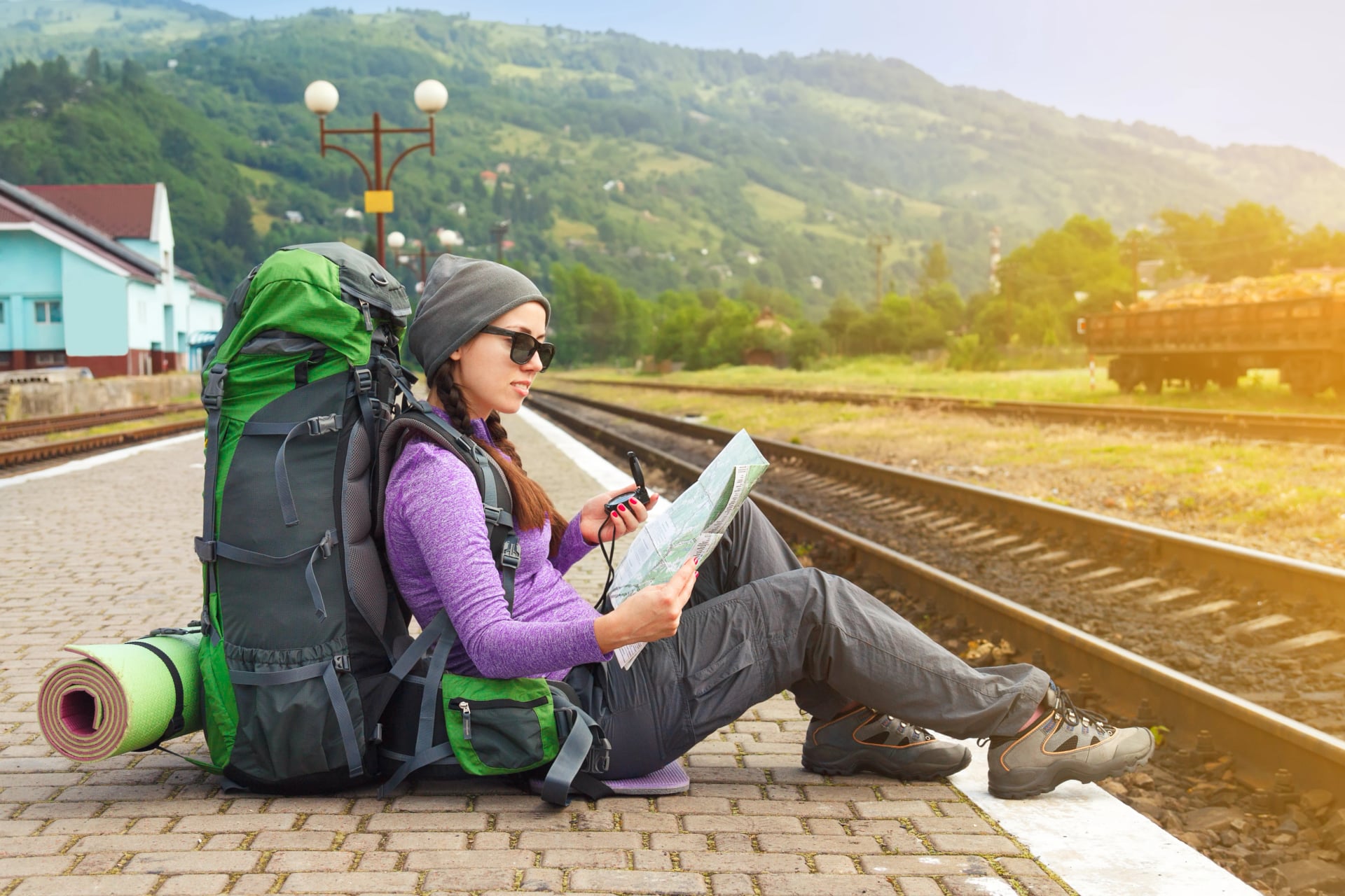 Girl hiker waiting train at the railway station