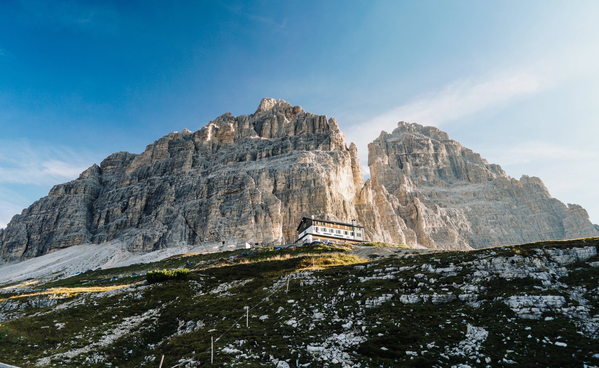 Rifugio de montagne sous des remparts rocheux vertigineux