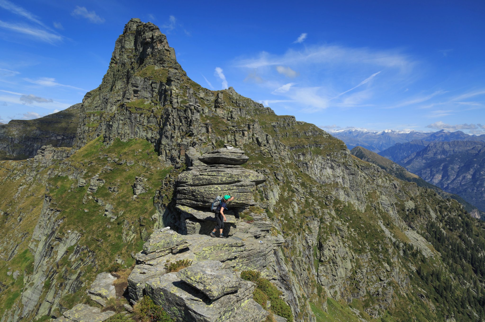 Female hiker on a narrow ridge of the Via Alta Verzasca, Switzerland.