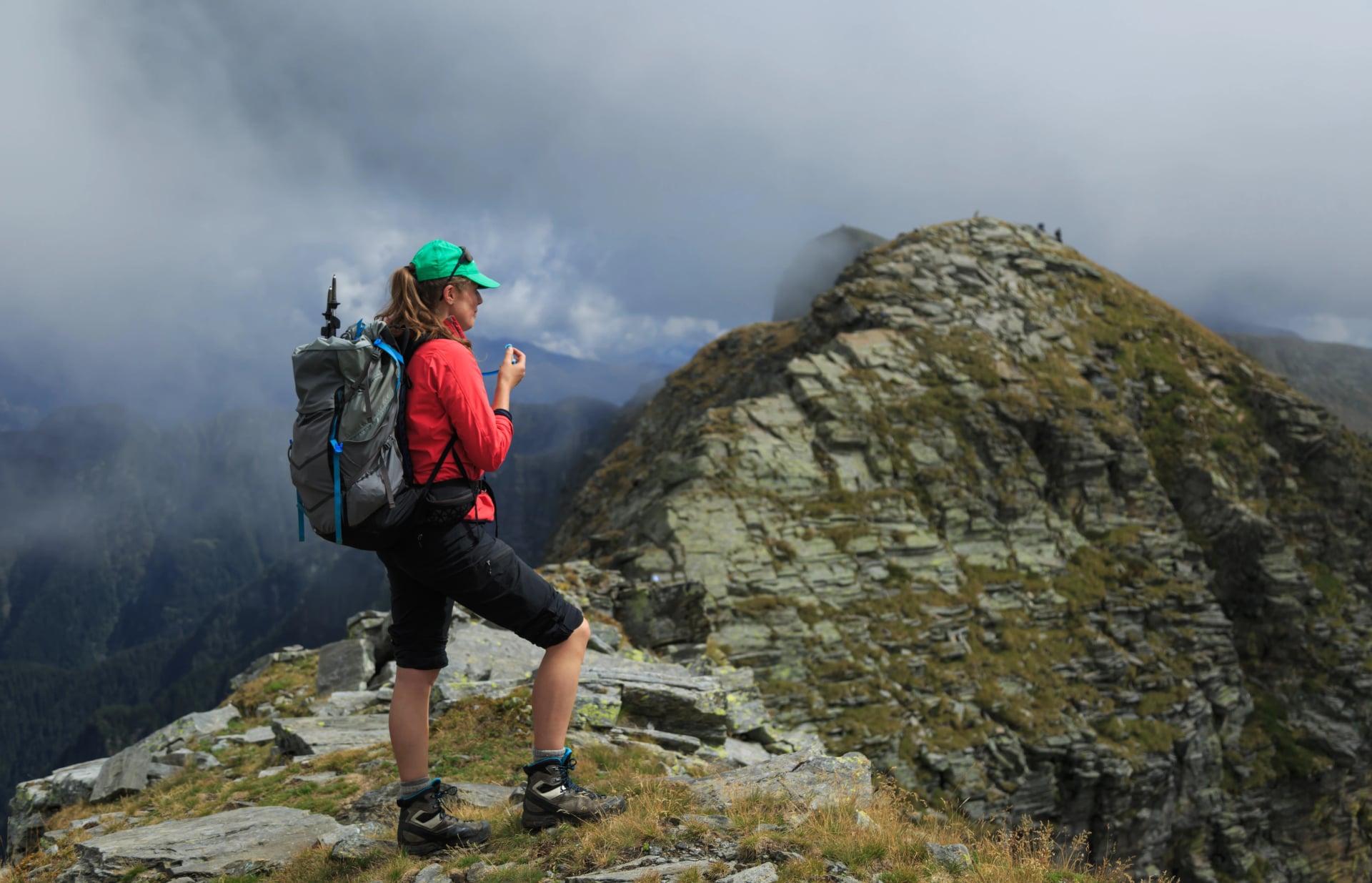 Female hiker on a narrow ridge in the mountains. Via Alta Verzasca, Switzerland.