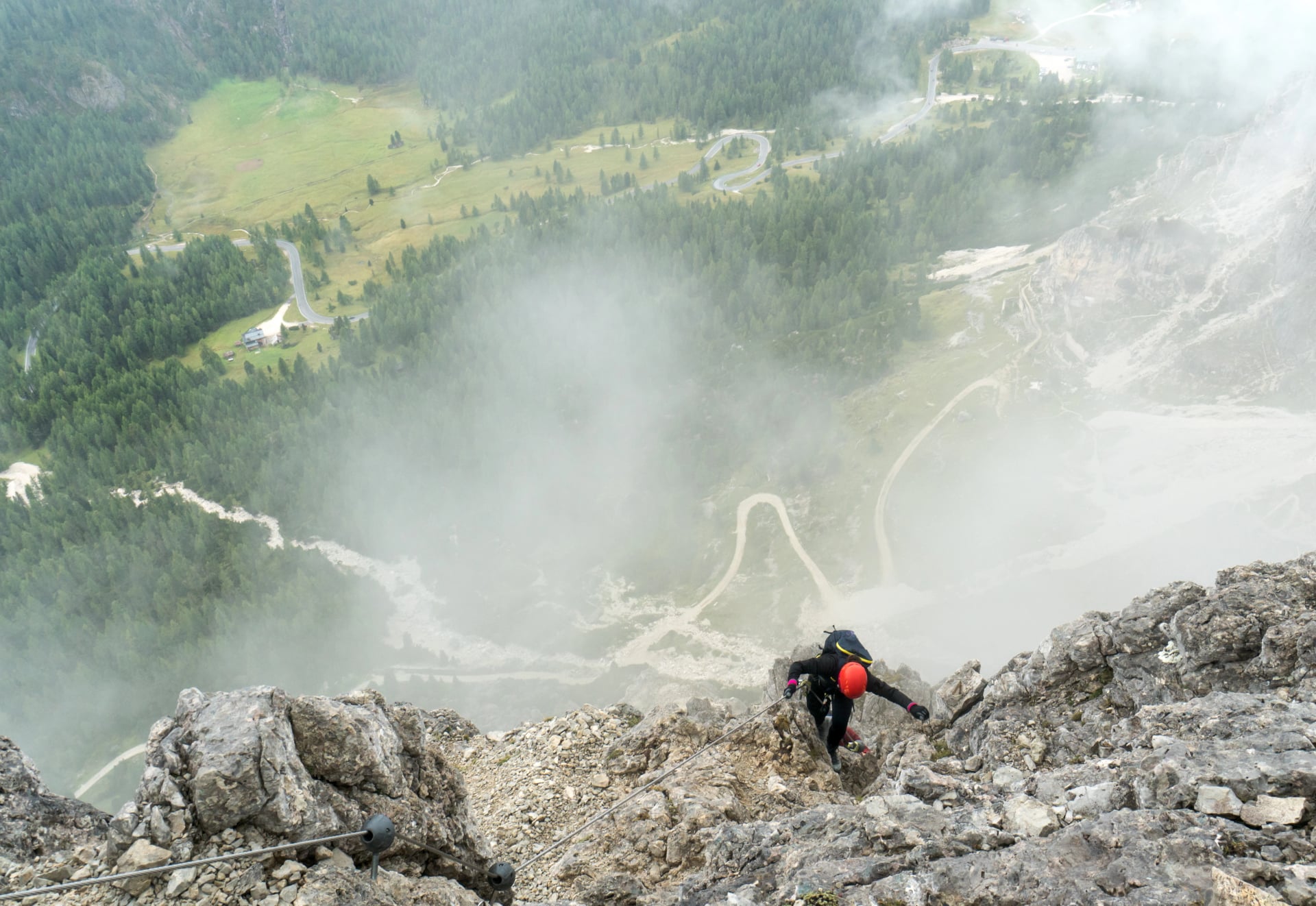 young attractive female mountain climber on a steep and exposed Via Ferrata in Alta Badia in the South Tyrol in the Italian Dolomites
