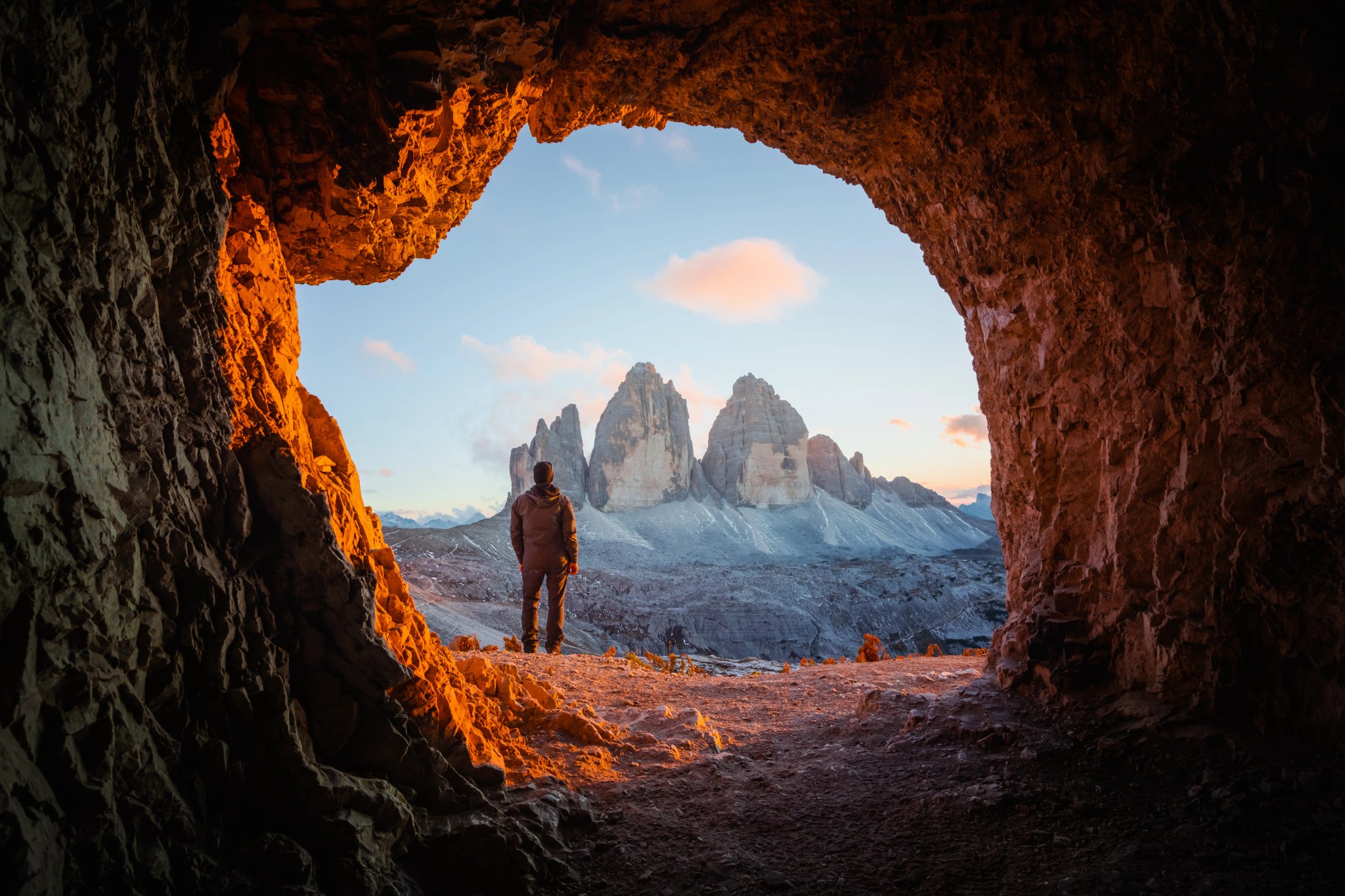 Tre Cime Di Lavaredo peaks in incredible orange sunset light. View from the cave in mountain against Three peaks of Lavaredo, Dolomite Alps, Italy, Europe. Landscape photography