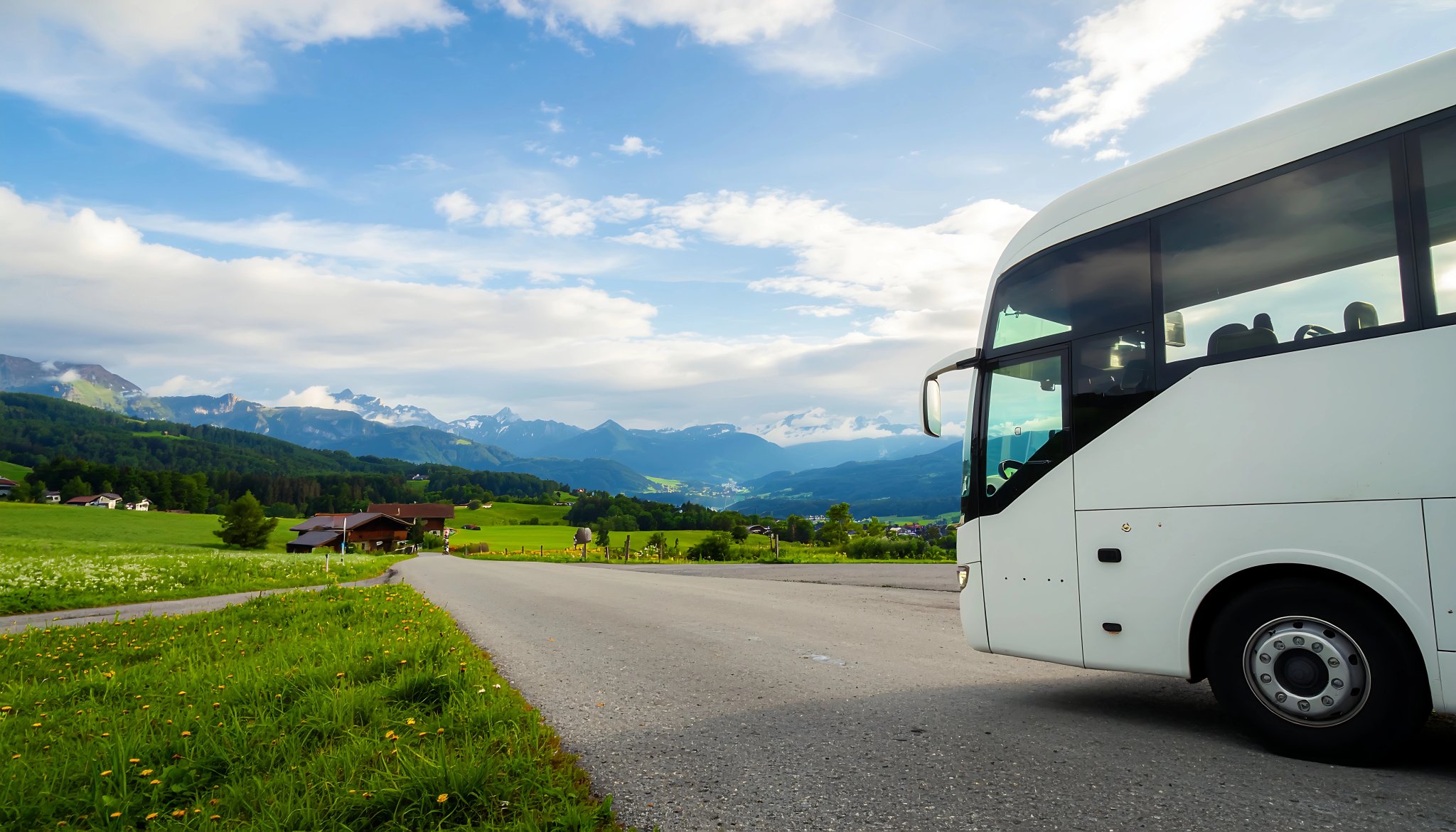 White Tour Bus on Scenic Mountain Road Journey.
