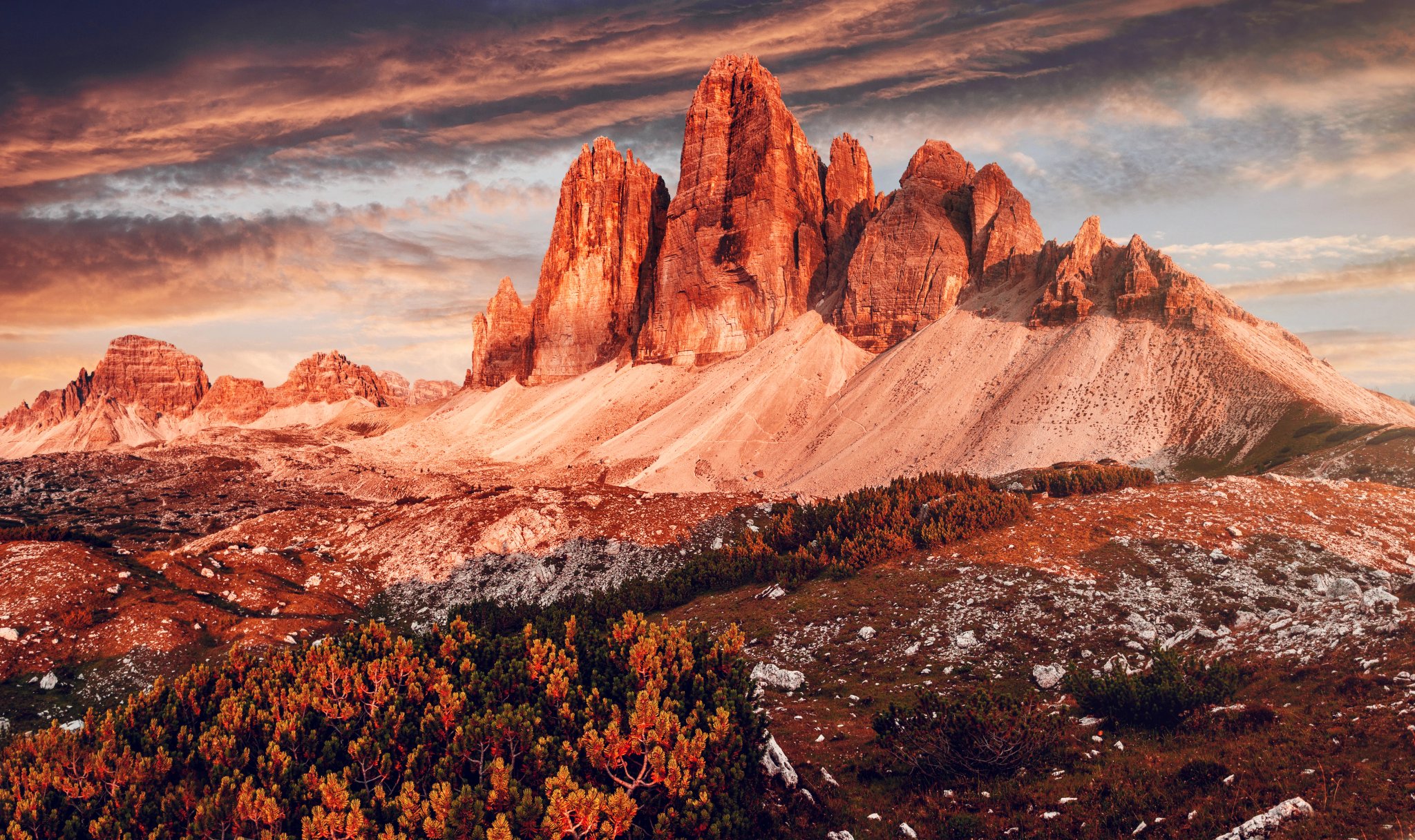 Meravigliosi alti territori alpini durante il tramonto. Paesaggio naturale sorprendente. Tre Cime di Laveredo, tre spettacolari picchi montuosi con cielo colorato, Dolomiti, Alto Adige, Italia. Immagine di un'area selvaggia.