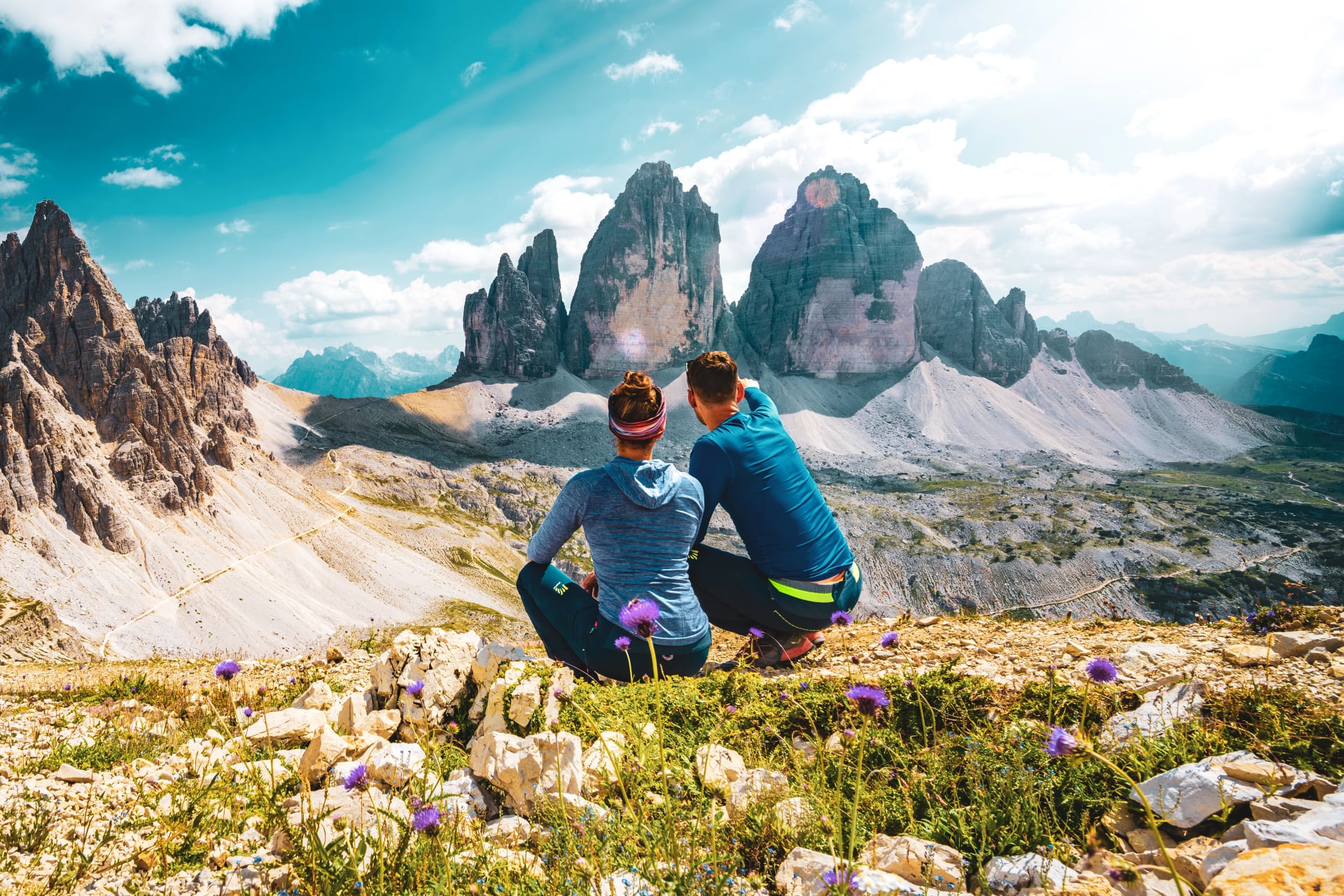 Young athletic couple enjoys scenic view on Monte Paterno and Tre Cime in the afternoon. Tre Cime, Dolomites, South Tirol, Italy, Europe.