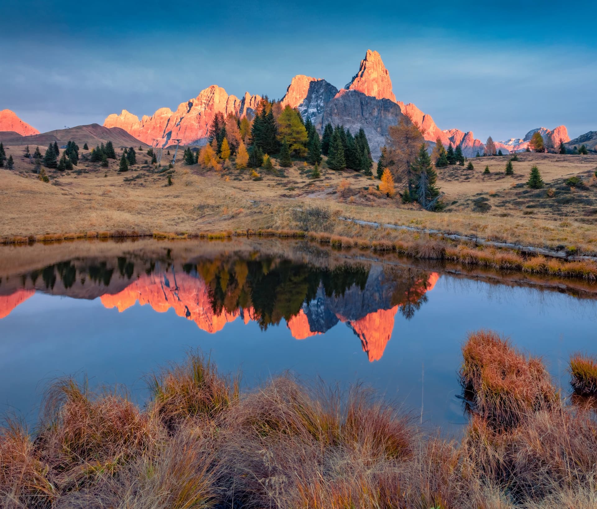 Cimon della Pala peak reflected in the calm waters of small mountain lake. Stunning autumn view of Dolomite Alps. Colorful evening scene of Italy, Europe. Traveling concept background.