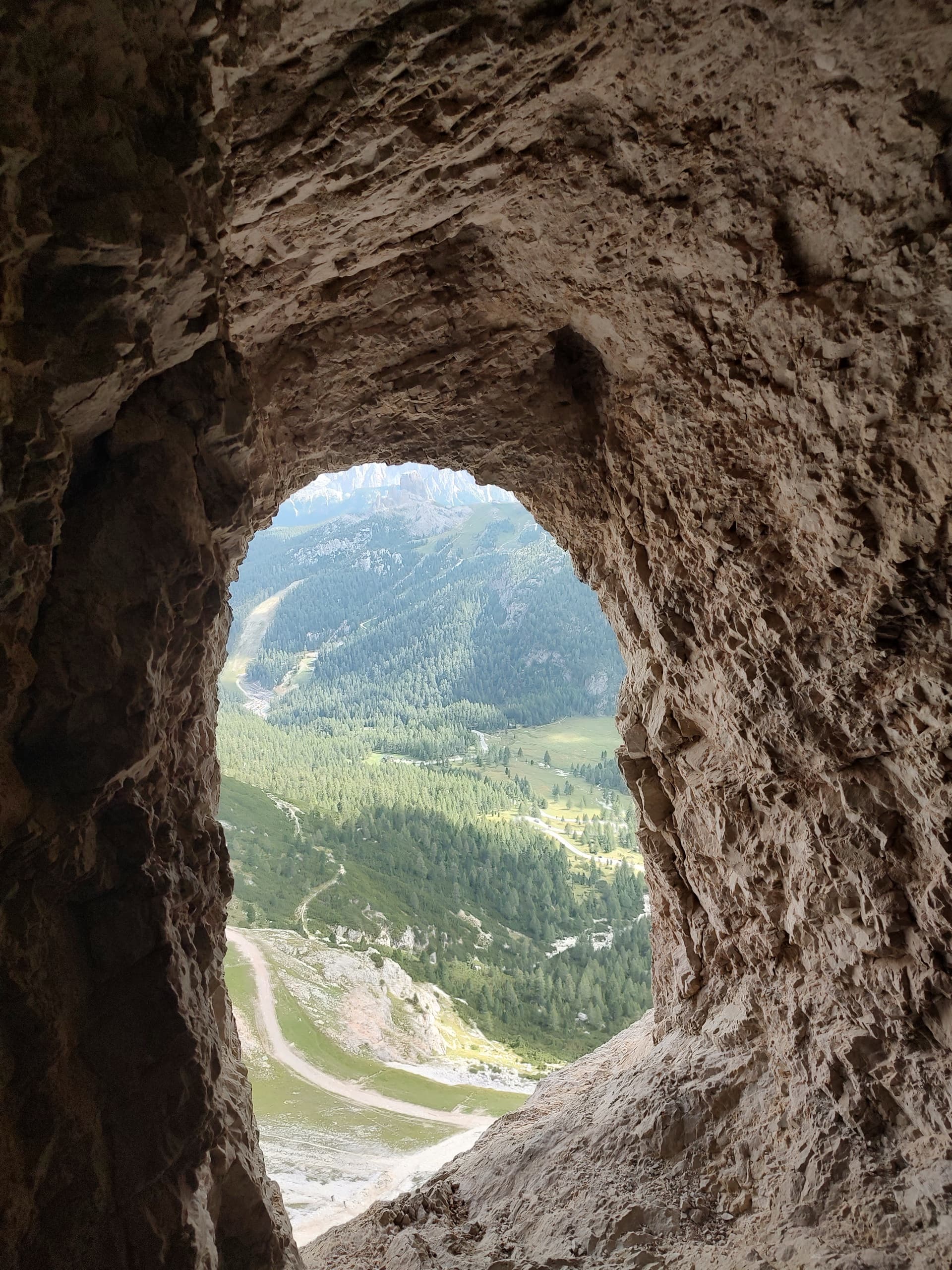 Mountain valley viewed through a natural rock window opening