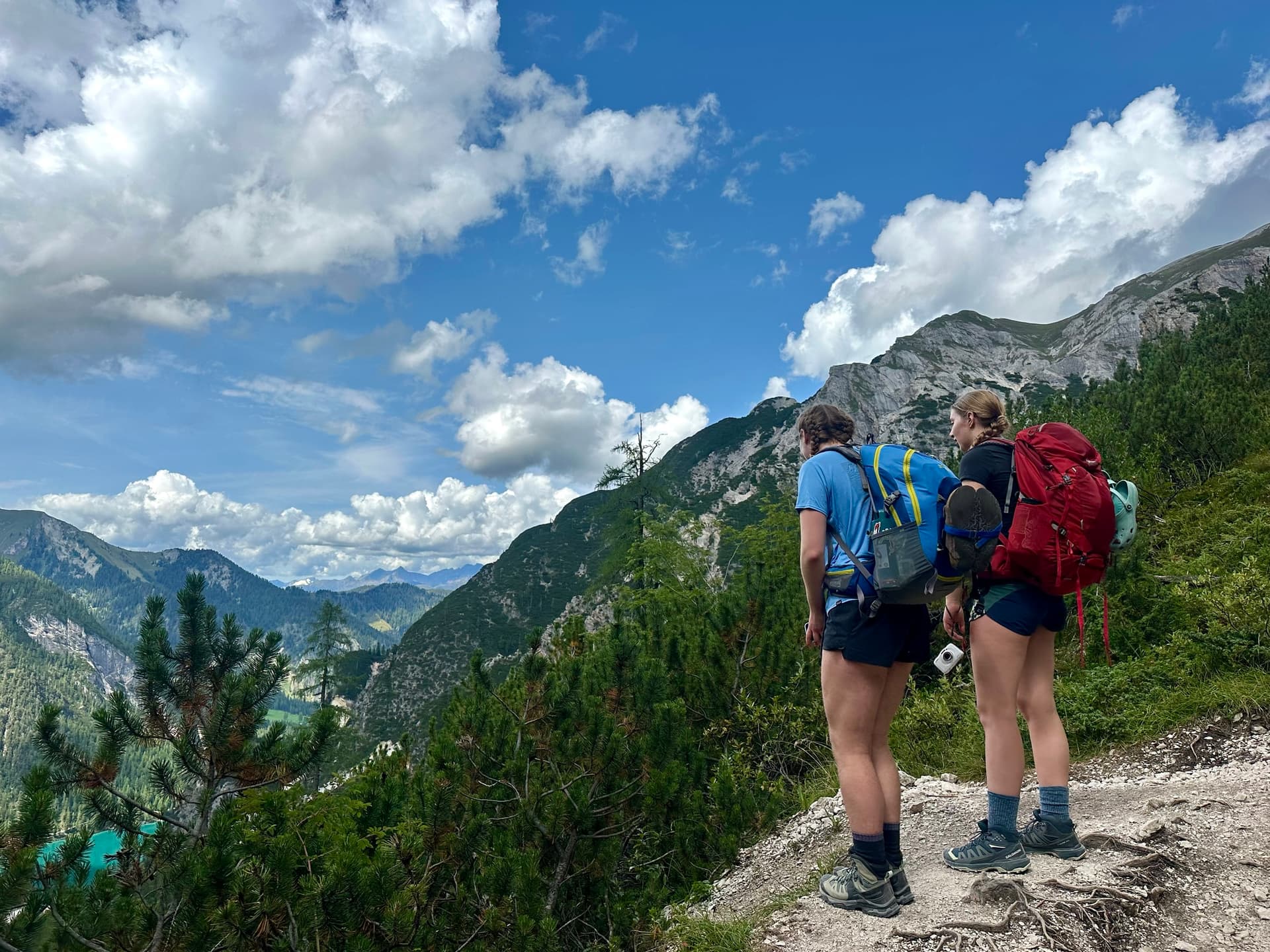 Two hikers with backpacks looking out over a deep mountain valley