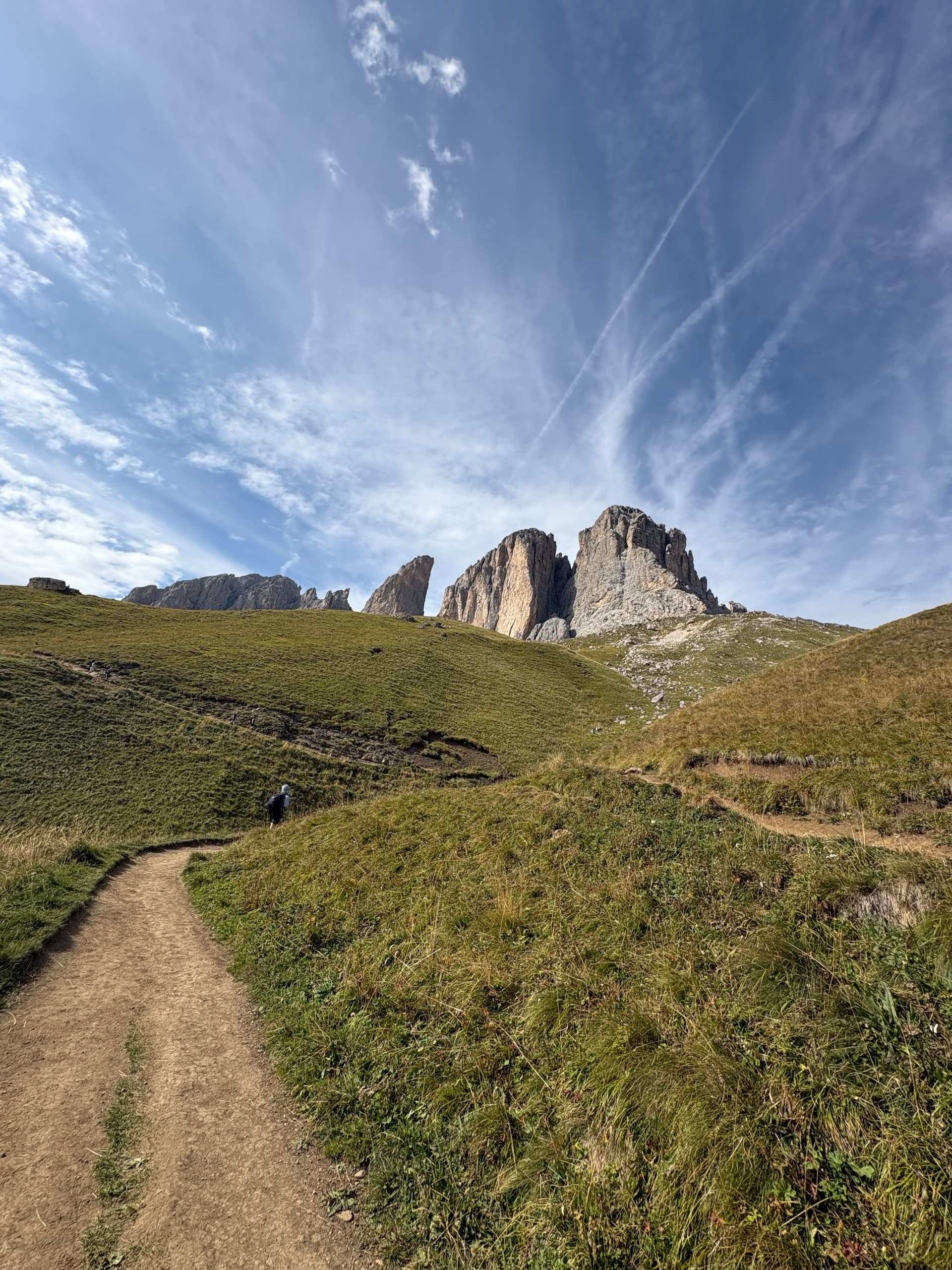 Hiking trail leading toward rocky mountain towers under a blue sky