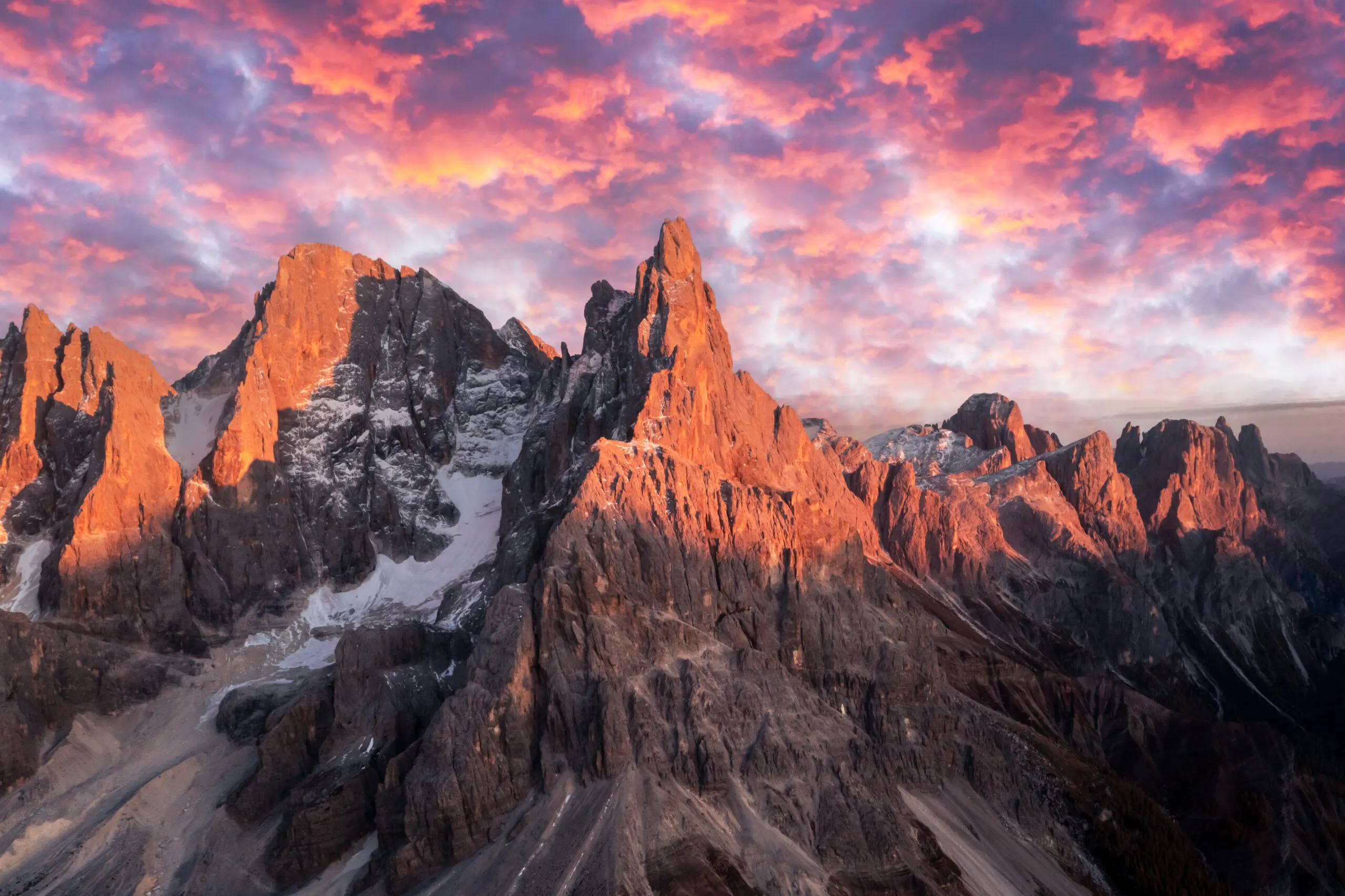 Pale di San Martinon vuoriryhmä auringonlaskun aikaan. Korkeat vuoret ja jäätikkö hehkuvat auringonlaskun valossa. San Martino di Castrozza, Dolomiitit, Trentino, Italia.