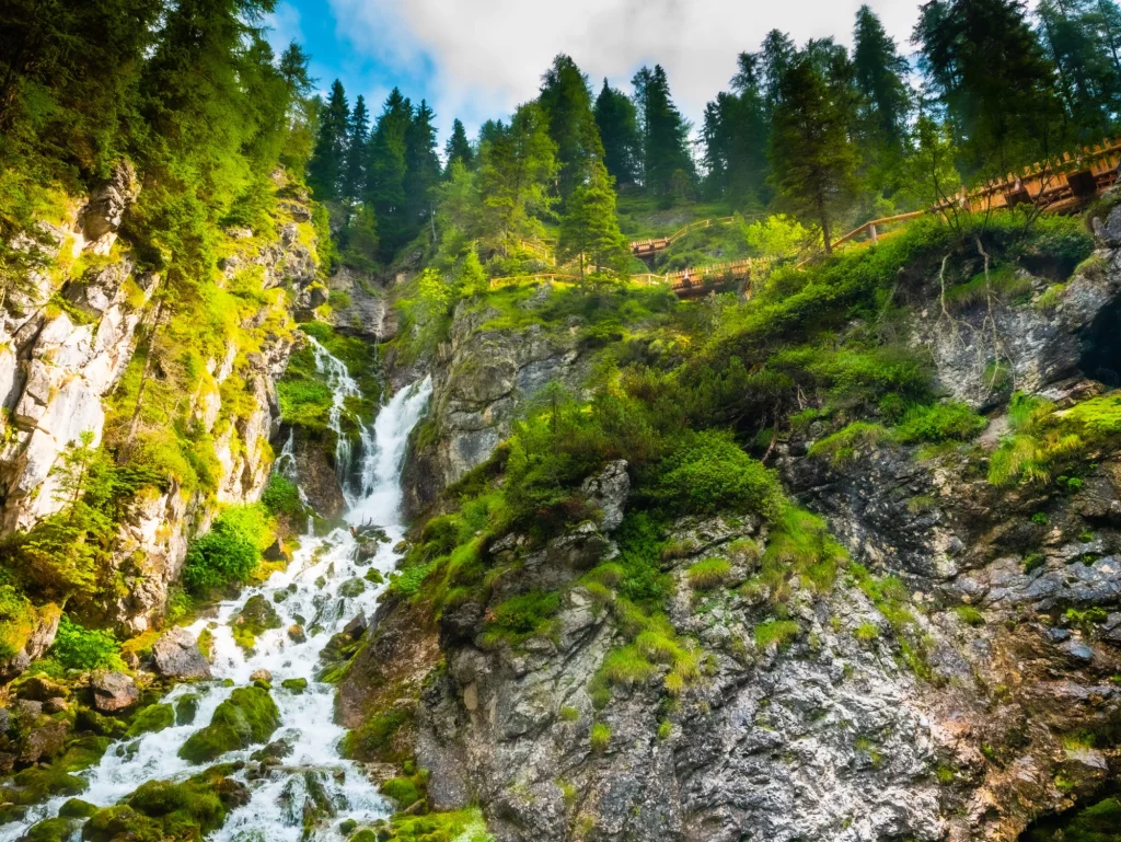 Laajakulmakuva Vallesinellan vesiputouksesta Italian Trentinon kansallispuiston metsässä.