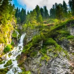 wide angle view of the Vallesinella waterfall in the forest of the Italian Trentino national park